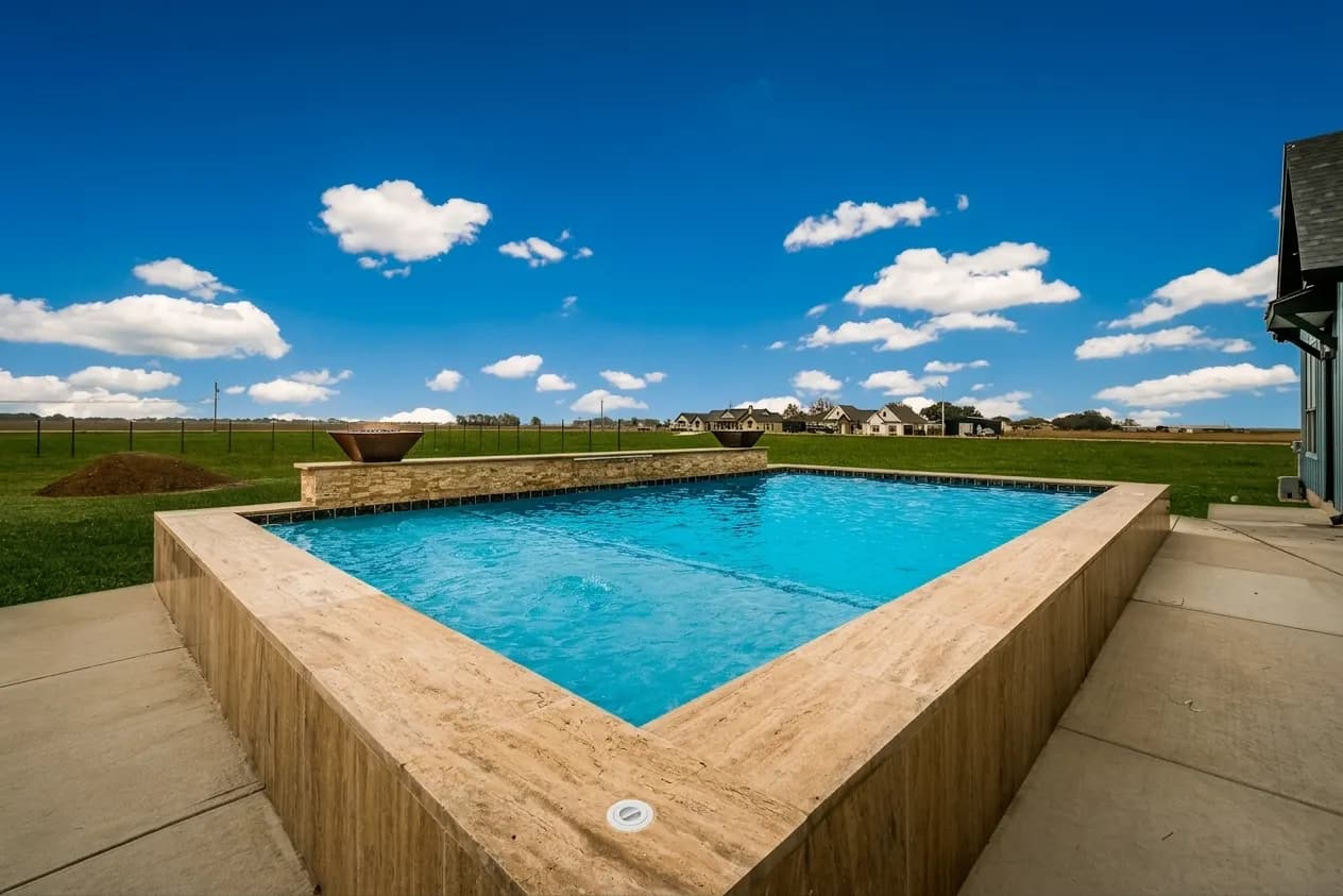 Custom gunite pool with raised walls and covered patio under open Hill Country sky