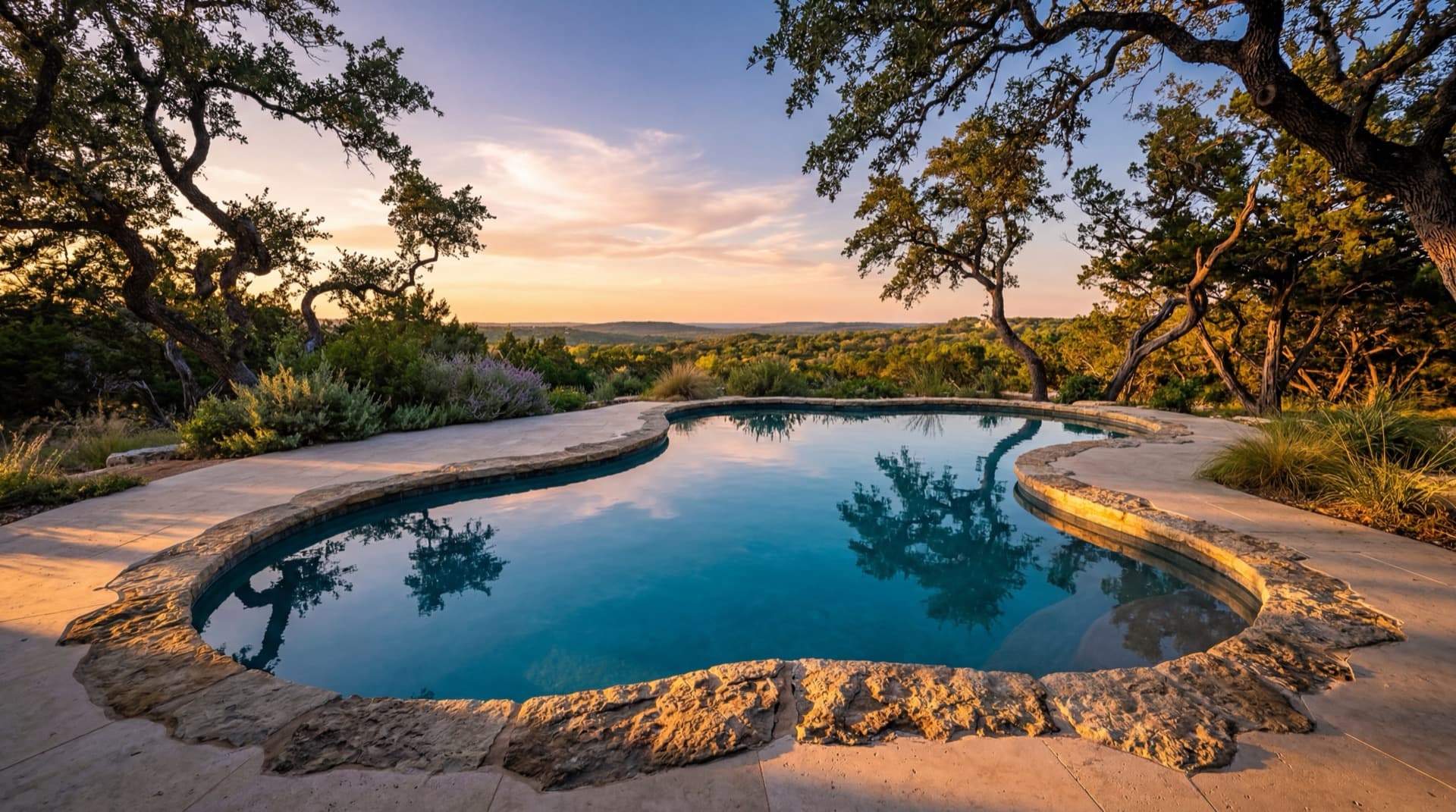 Double Creek — Raised limestone walls, dual fire bowls, and a covered patio framing open Hill Country sky.