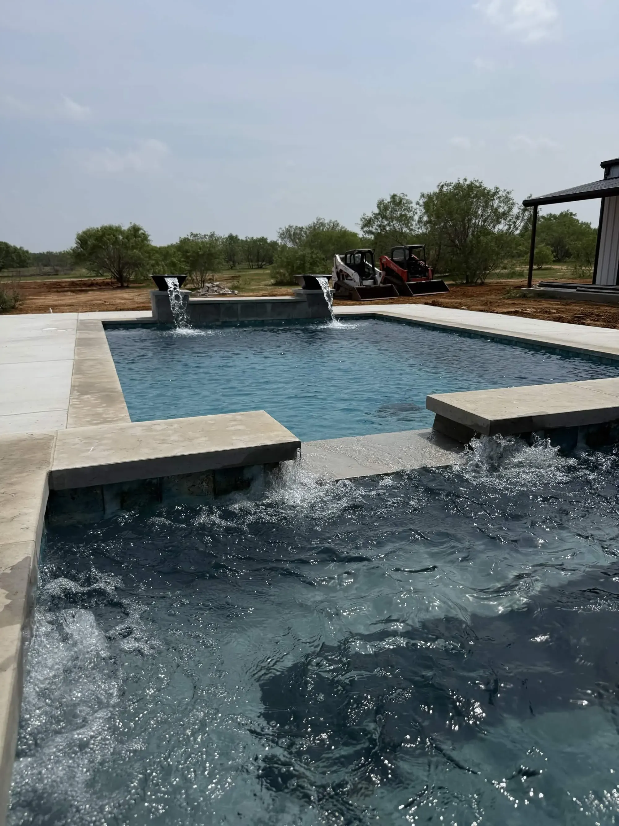 Custom gunite pool with water features and stone coping