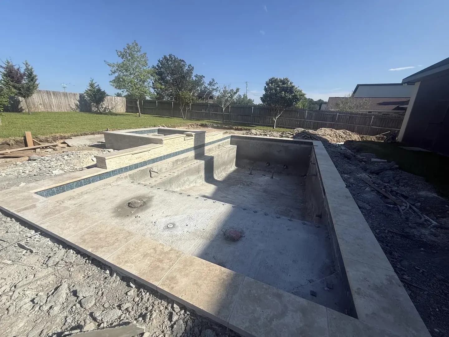 Tile and coping set by hand on a pre-plaster gunite pool shell